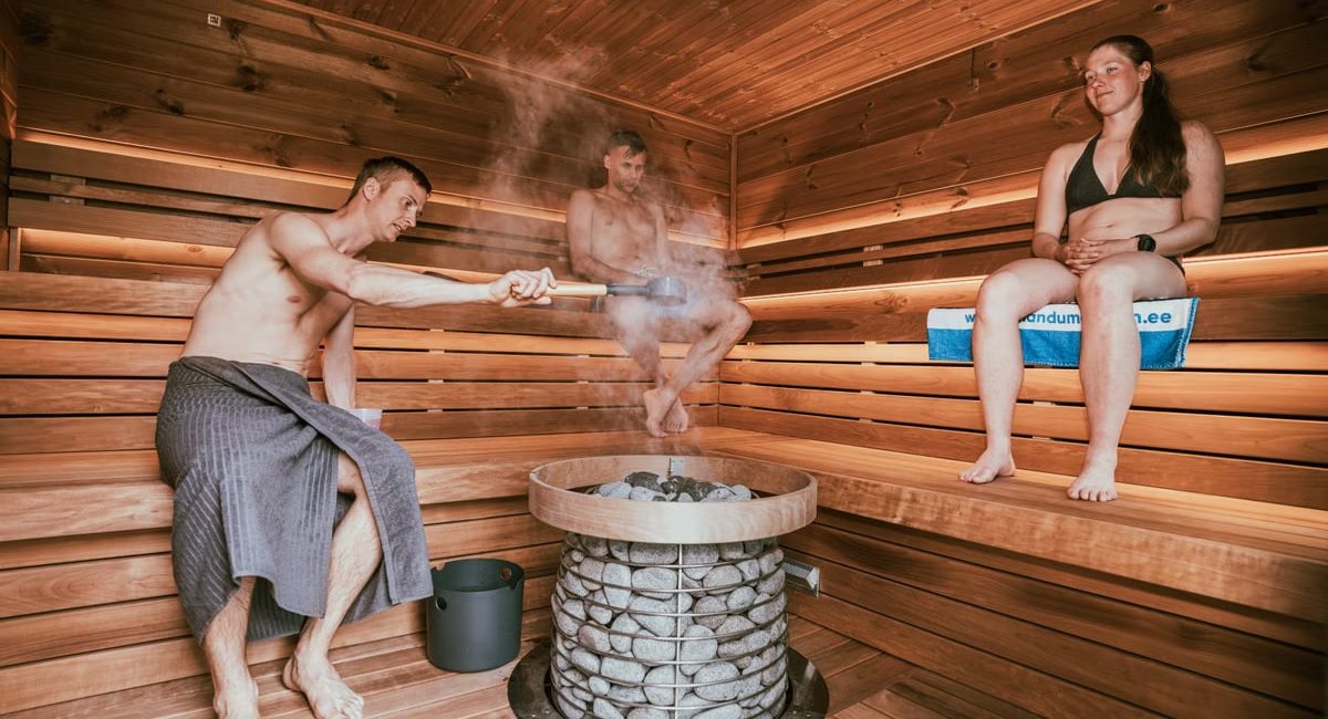 Three people enjoying a steamy sauna session, embracing wellness and relaxation.