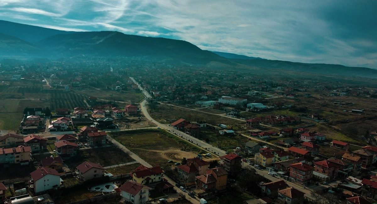 an aerial view of a town with mountains in the background