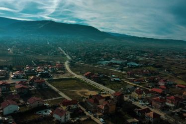 an aerial view of a town with mountains in the background
